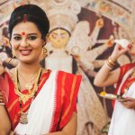 Durga Puja is one of the biggest festivals of India, especially of Kolkata. It is a celebration of the Goddess Durga's victory over evil buffalo Mahishasura. The festival honors the powerful female force. This article is for all the ladies who wish to celebrate this force by dressing up in traditional Indian Sarees. We have handpicked some styles exclusively for Durga Puja celebrations.