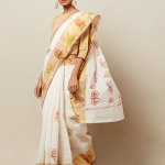 The sea of gold against white sarees is one of the most memorable images of Onam, and why not, this traditional Kerala saree is a signature look recognized anywhere. But what if you want to look a tiny bit extra special, or add oomph to the proceedings as hostess? You can still be traditional with an extra dose of glamour with these gorgeous white and gold sarees that we have handpicked from all over the internet. Order them quick in time for the festivities!